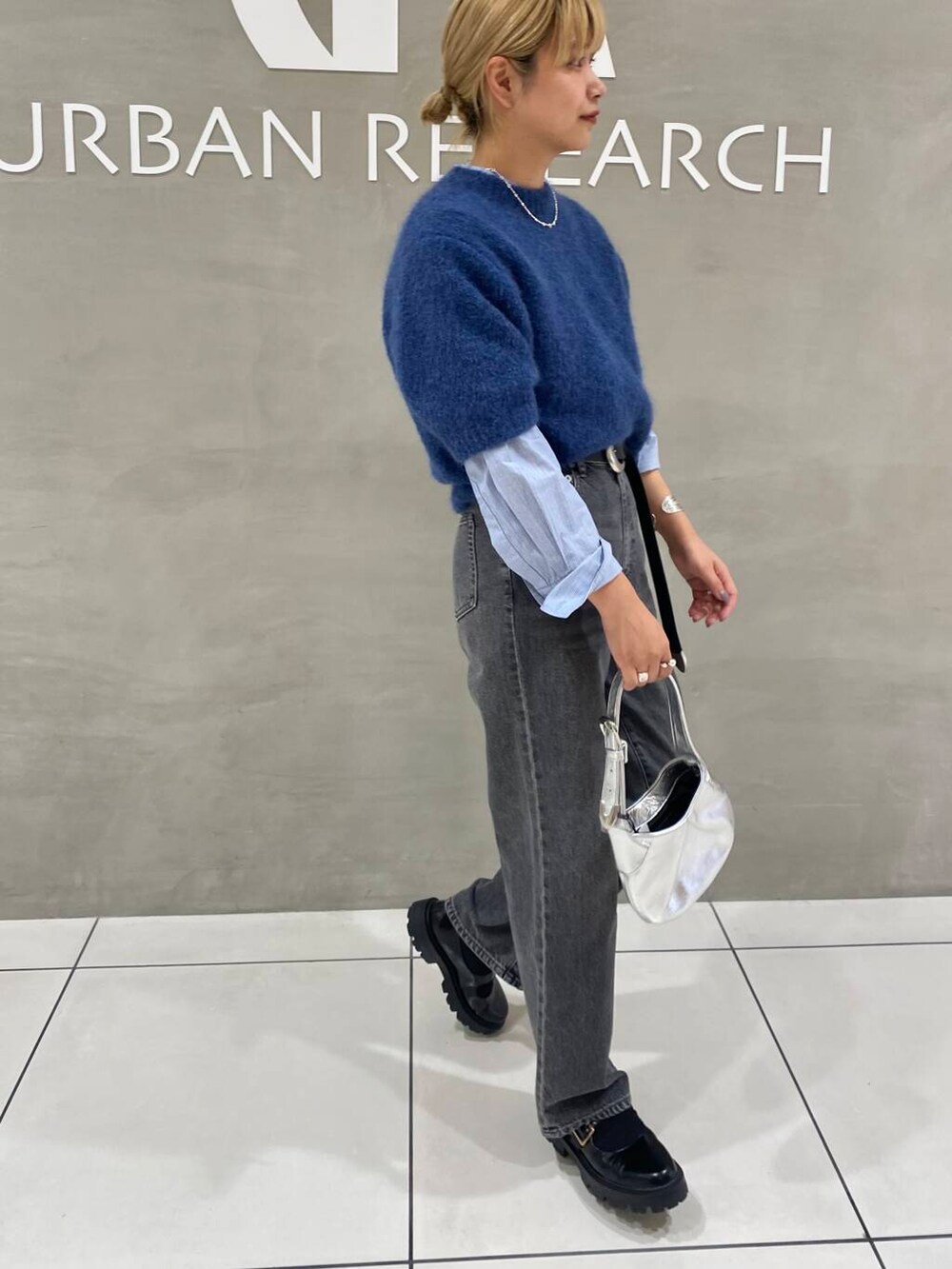 ブラック系のデニムパンツ、ブラック系のその他シューズ、ブルー系のTシャツ/カットソーを着用したレディースの秋コーディネートの3枚目の写真