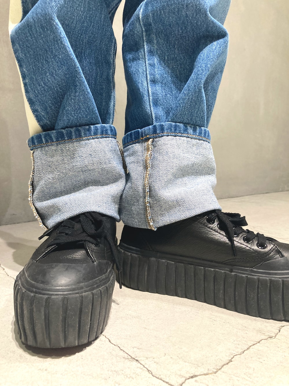 レッド系のショルダーバッグ、ブルー系のデニムパンツ、イエロー系のニット/セーターを着用したレディースの夏コーディネートの3枚目の写真