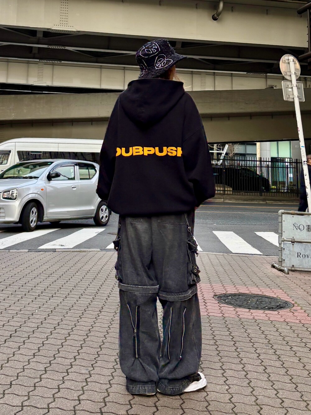 ブラック系のパーカー、ブラック系のデニムパンツ、ブラック系のハットを着用したレディースの春コーディネートの3枚目の写真