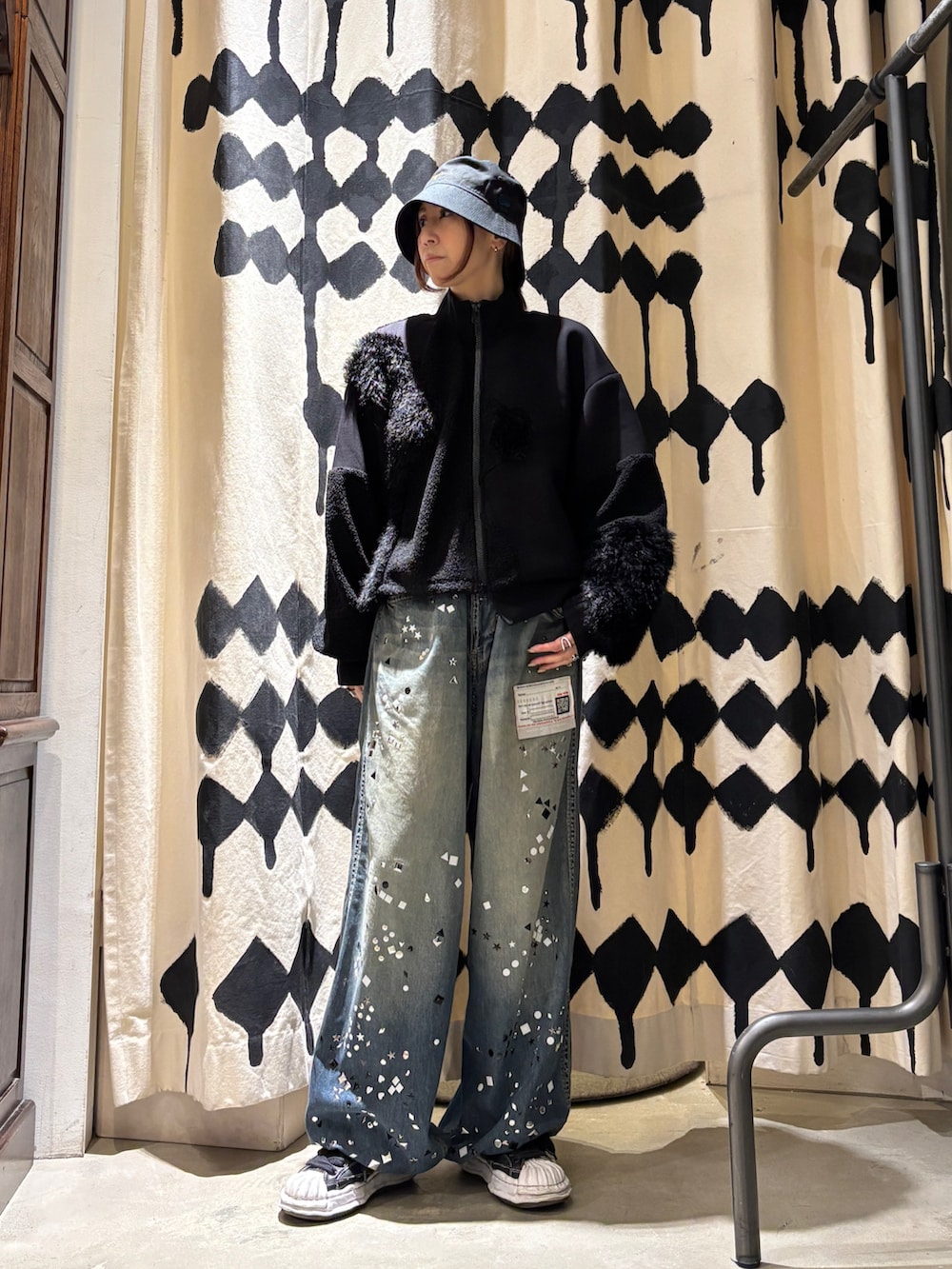 ブラック系のブルゾン、ブルー系のデニムパンツを着用したレディースの秋コーディネートの2枚目の写真