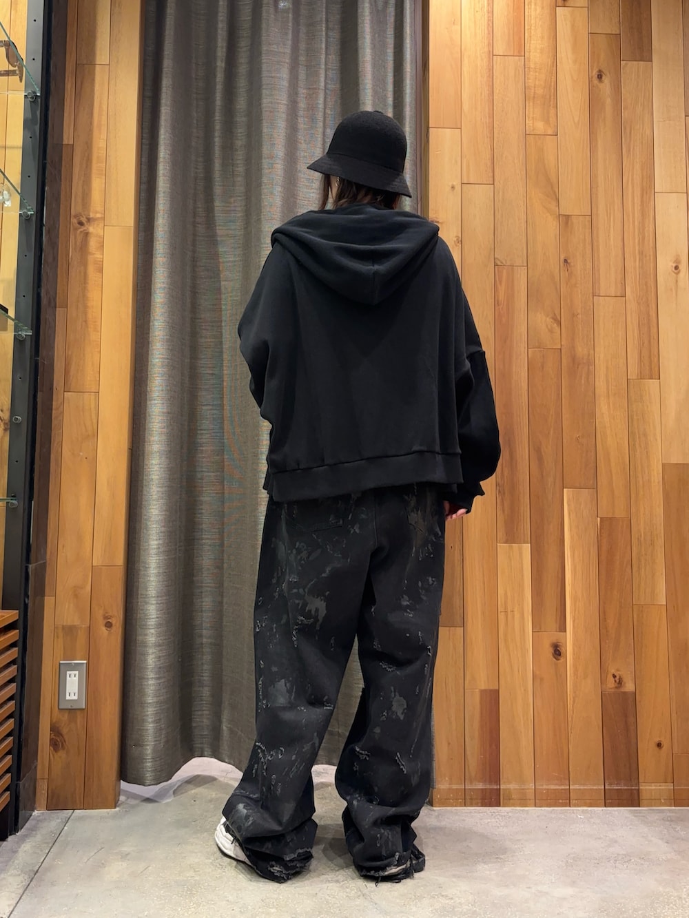 ブラック系のパーカー、ホワイト系のTシャツ/カットソー、ブラック系のデニムパンツを着用したレディースの冬コーディネートの3枚目の写真