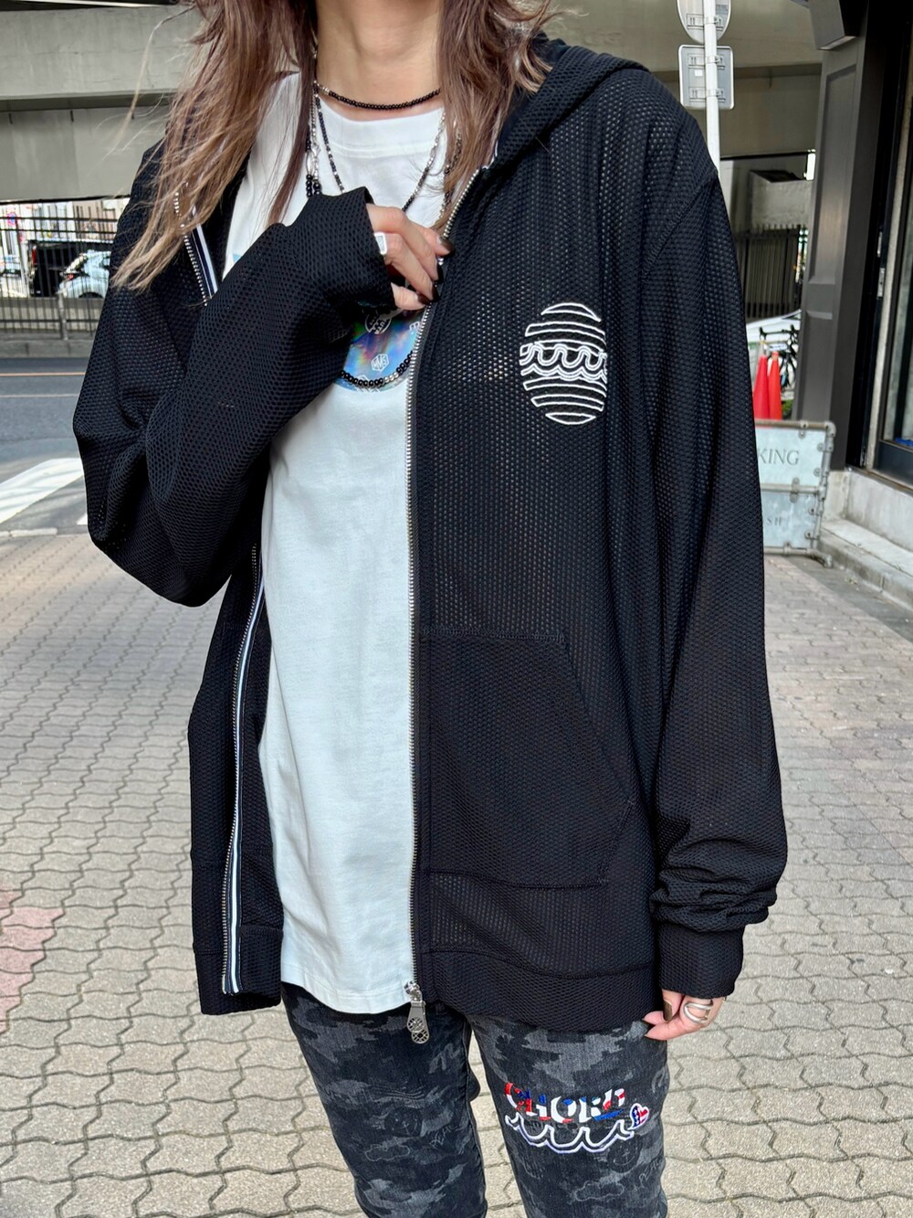 ホワイト系のTシャツ/カットソー、ブラック系のデニムパンツ、ブラック系のパーカーを着用したレディースの夏コーディネートの4枚目の写真