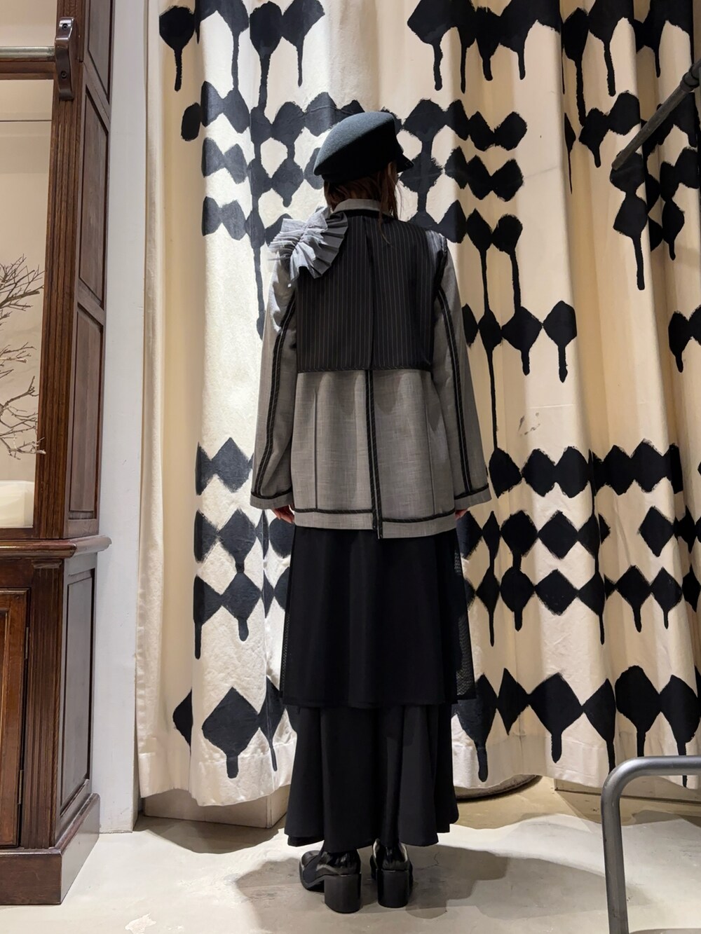 グレー系のテーラードジャケット、ブラック系のスカートを着用したレディースの冬コーディネートの3枚目の写真