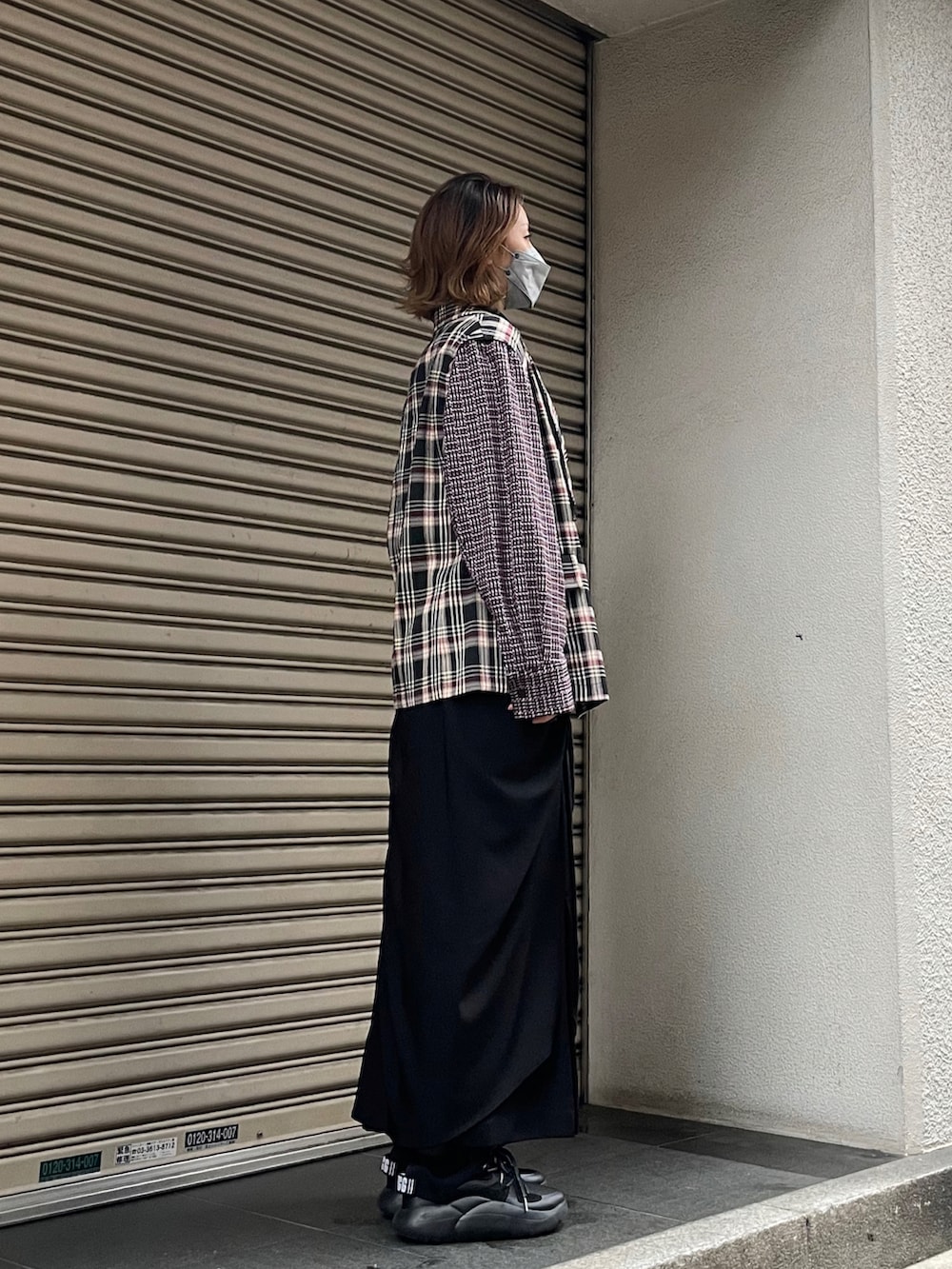 ブラック系のテーラードジャケット、ブラック系のスカートを着用したレディースの冬コーディネートの2枚目の写真