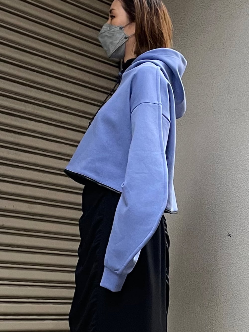 ブルー系のパーカー、ブラック系のスカートを着用したレディースの冬コーディネートの2枚目の写真