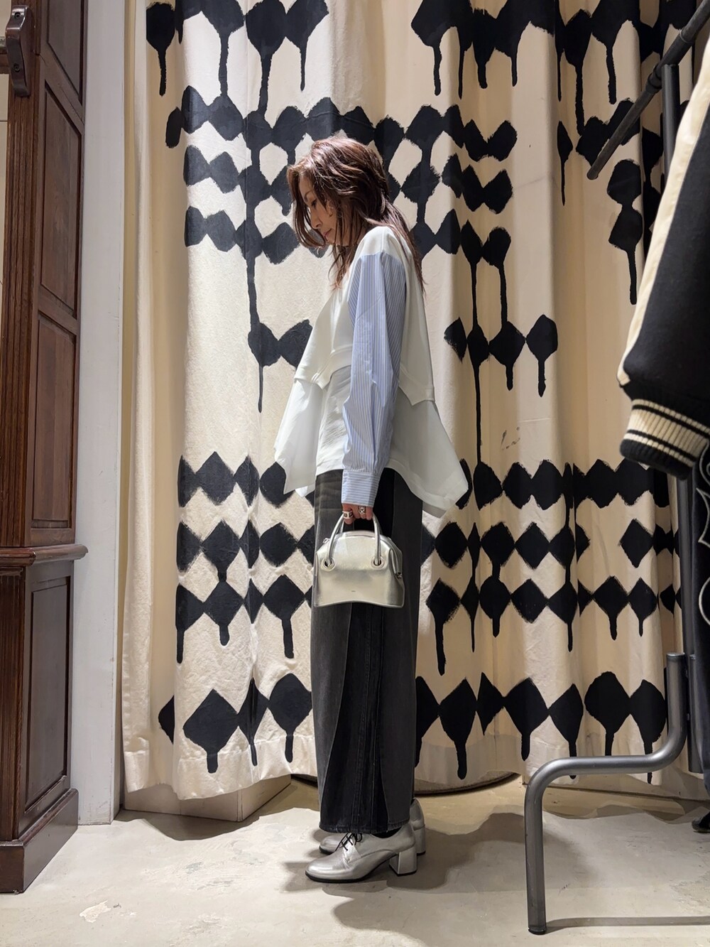 シルバー系のショルダーバッグ、ブラック系のデニムパンツ、ホワイト系のTシャツ/カットソーを着用したレディースの春コーディネートの2枚目の写真