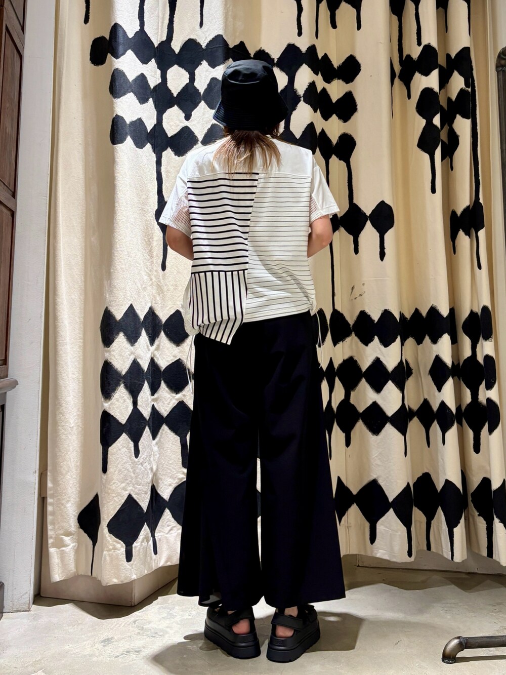 ホワイト系のTシャツ/カットソー、ブラック系のその他パンツ、ブラック系のサンダルを着用したレディースの春コーディネートの3枚目の写真