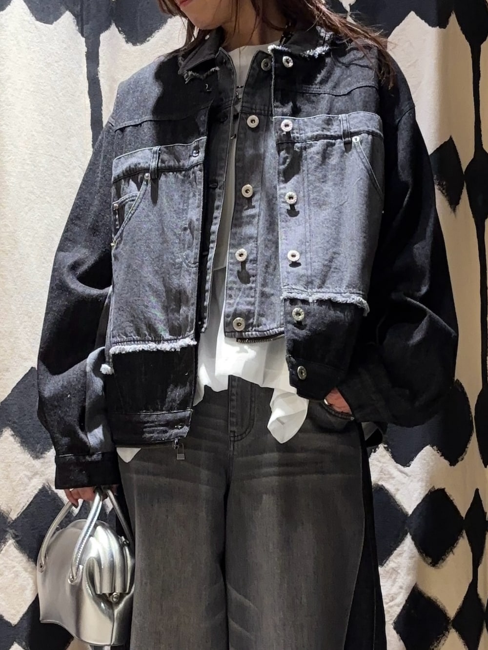 シルバー系のショルダーバッグ、ホワイト系のTシャツ/カットソー、ブラック系のデニムジャケットを着用したレディースの春コーディネートの5枚目の写真
