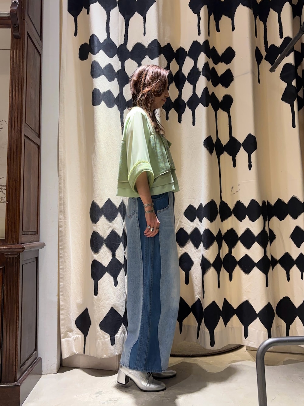 シルバー系のショルダーバッグ、グリーン系のシャツ/ブラウス、ブルー系のデニムパンツを着用したレディースの春コーディネートの2枚目の写真