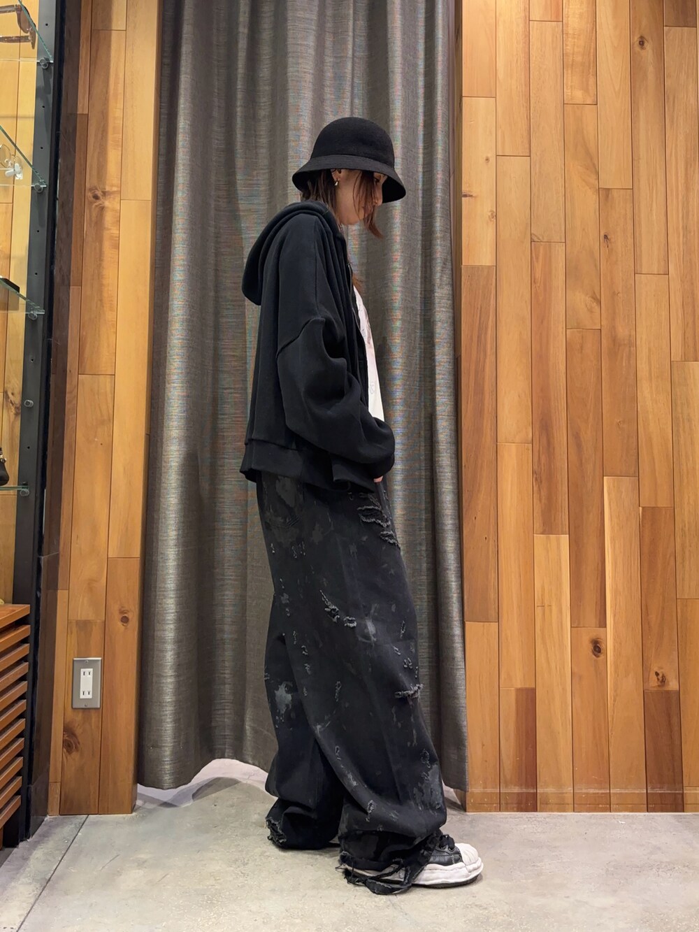 ブラック系のパーカー、ホワイト系のTシャツ/カットソー、ブラック系のデニムパンツを着用したレディースの冬コーディネートの4枚目の写真