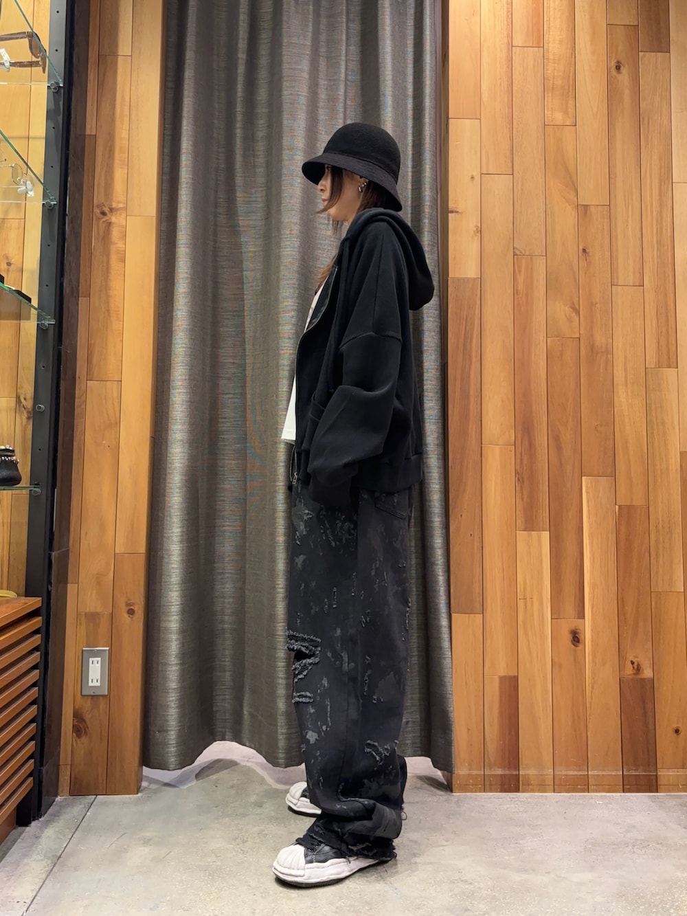 ブラック系のパーカー、ホワイト系のTシャツ/カットソー、ブラック系のデニムパンツを着用したレディースの冬コーディネートの2枚目の写真