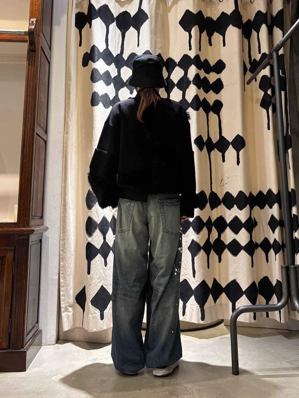 ブラック系のブルゾン、ブルー系のデニムパンツを着用したレディースの秋コーディネートの3枚目の写真