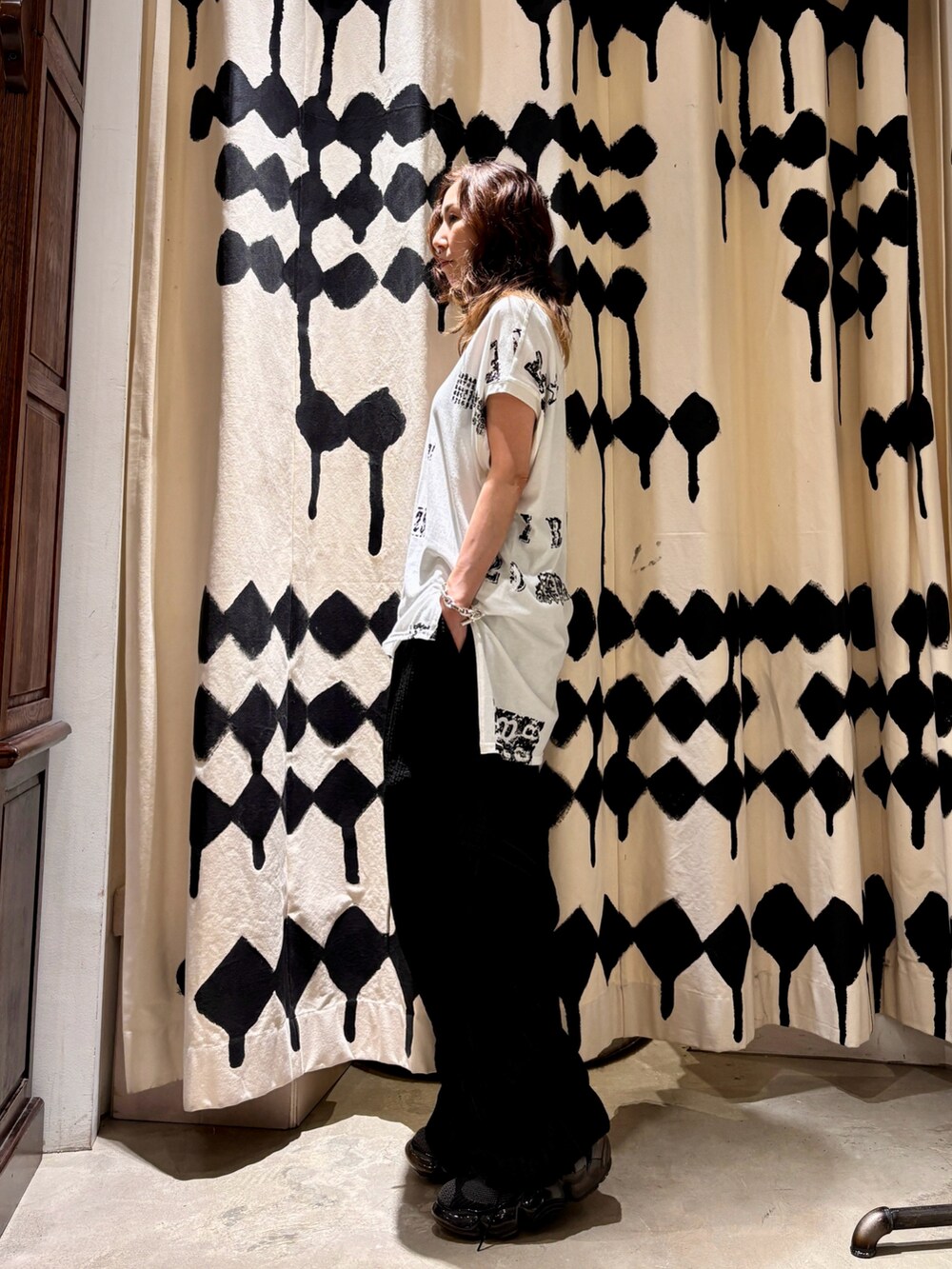 ブラック系のその他パンツ、ブラック系のスニーカー、ホワイト系のTシャツ/カットソーを着用したレディースの夏コーディネートの2枚目の写真