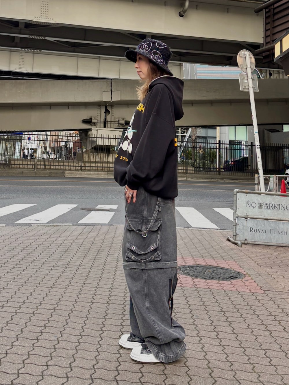 ブラック系のパーカー、ブラック系のデニムパンツ、ブラック系のハットを着用したレディースの春コーディネートの2枚目の写真