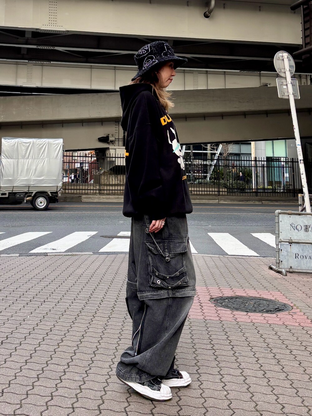 ブラック系のパーカー、ブラック系のデニムパンツ、ブラック系のハットを着用したレディースの春コーディネートの4枚目の写真