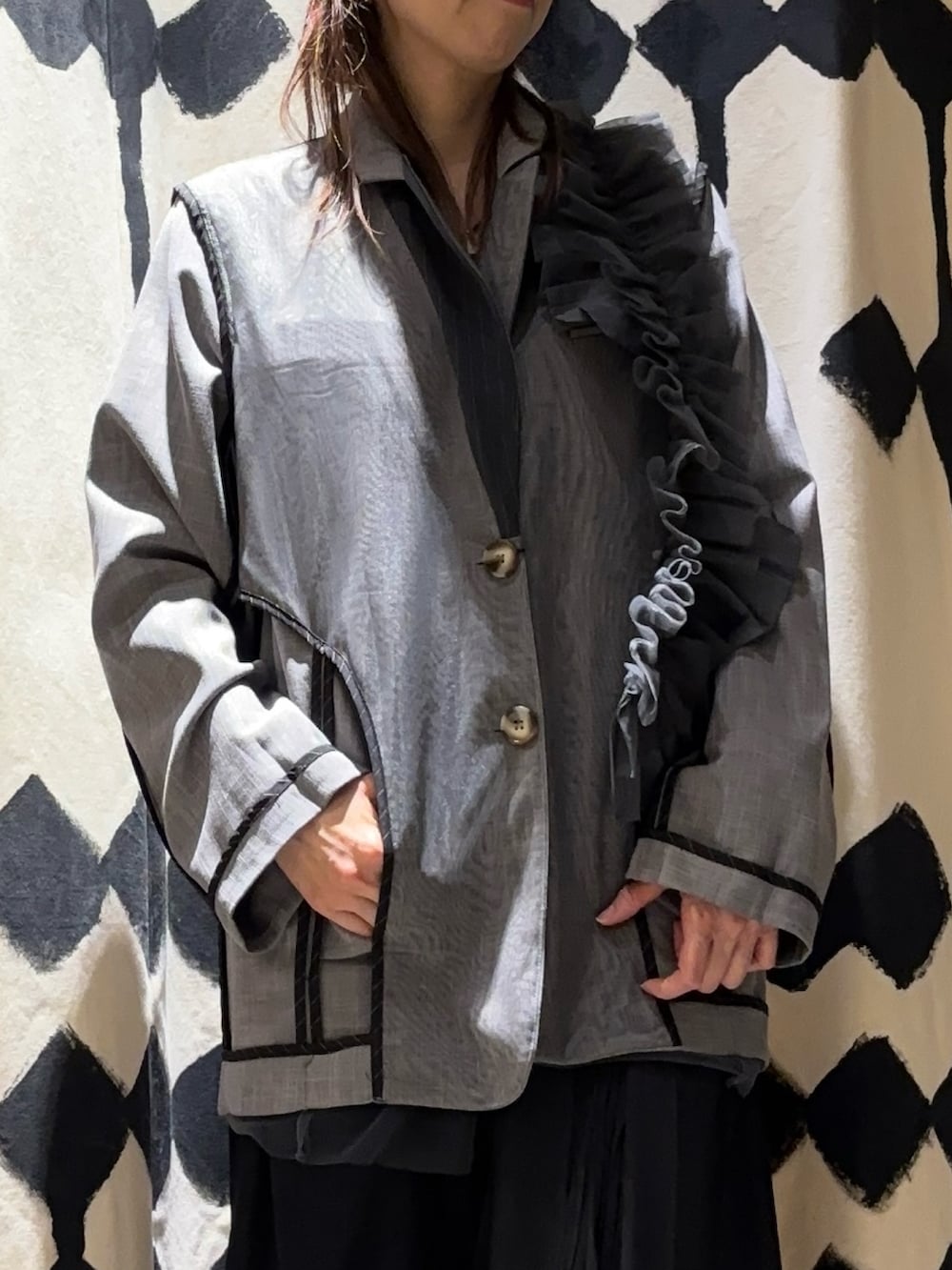 グレー系のテーラードジャケット、ブラック系のスカートを着用したレディースの冬コーディネートの5枚目の写真