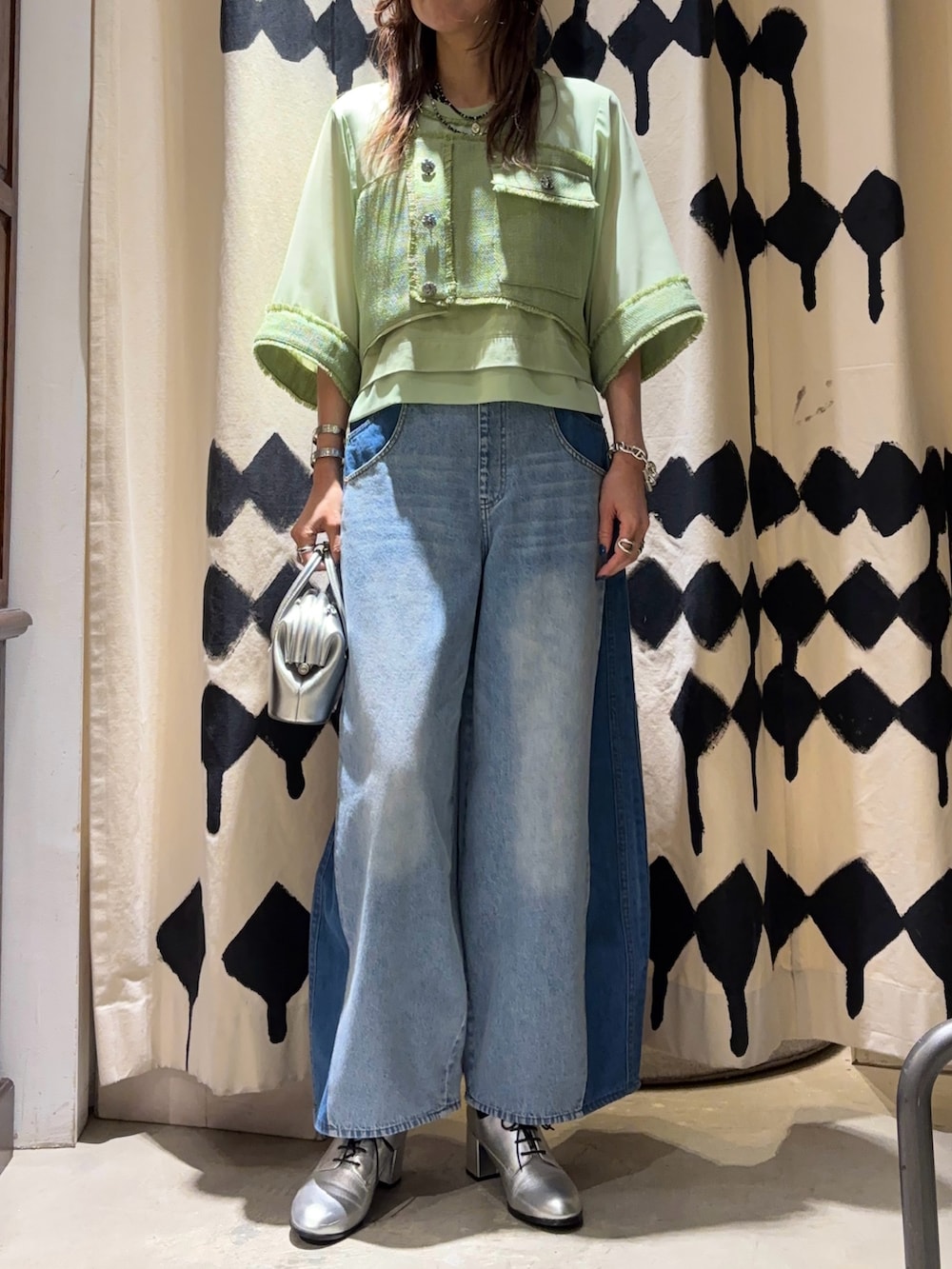 シルバー系のショルダーバッグ、グリーン系のシャツ/ブラウス、ブルー系のデニムパンツを着用したレディースの春コーディネートの5枚目の写真