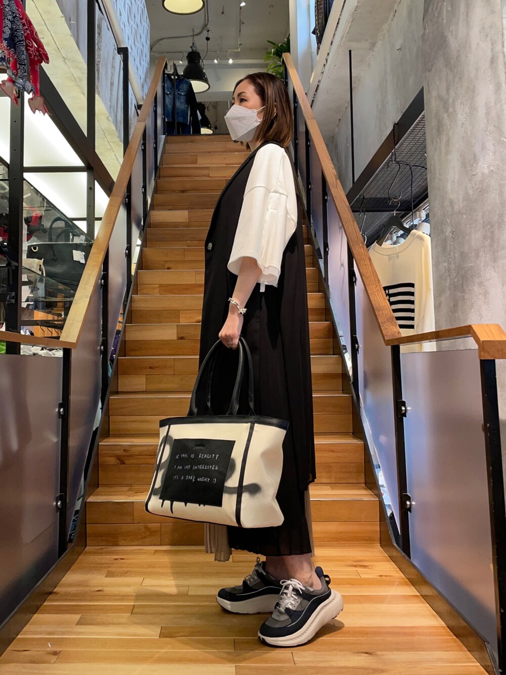 ホワイト系のTシャツ/カットソー、ブラック系のその他パンツ、ブラック系のベストを着用したレディースの春コーディネートの2枚目の写真