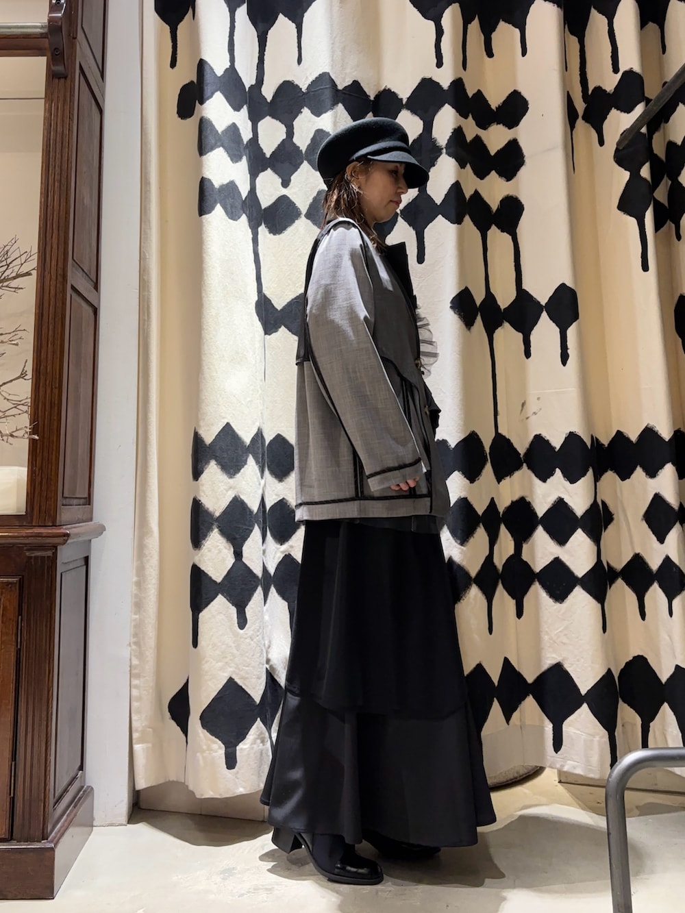 グレー系のテーラードジャケット、ブラック系のスカートを着用したレディースの冬コーディネートの4枚目の写真