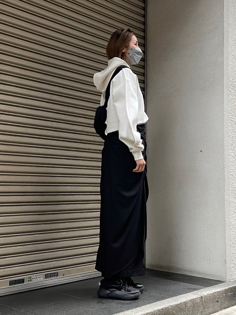 ホワイト系のパーカー、ブラック系のボディバッグ/ウエストポーチを着用したレディースの冬コーディネートの2枚目の写真