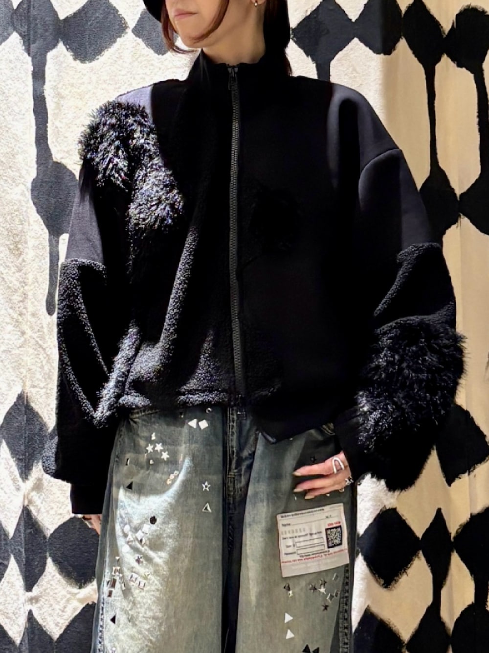 ブラック系のブルゾン、ブルー系のデニムパンツを着用したレディースの秋コーディネートの5枚目の写真