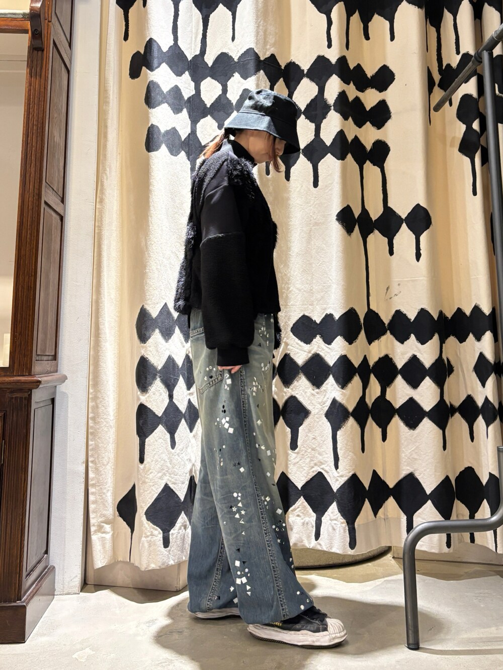 ブラック系のブルゾン、ブルー系のデニムパンツを着用したレディースの秋コーディネートの4枚目の写真