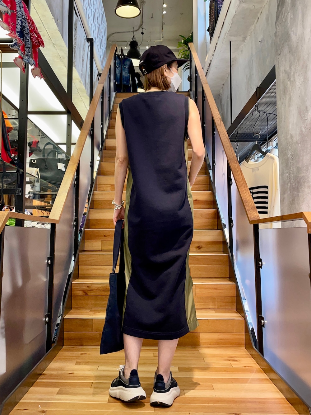 レッド系のワンピース/ドレス、ブルー系のトートバッグ、ブルー系のキャップを着用したレディースの春コーディネートの2枚目の写真