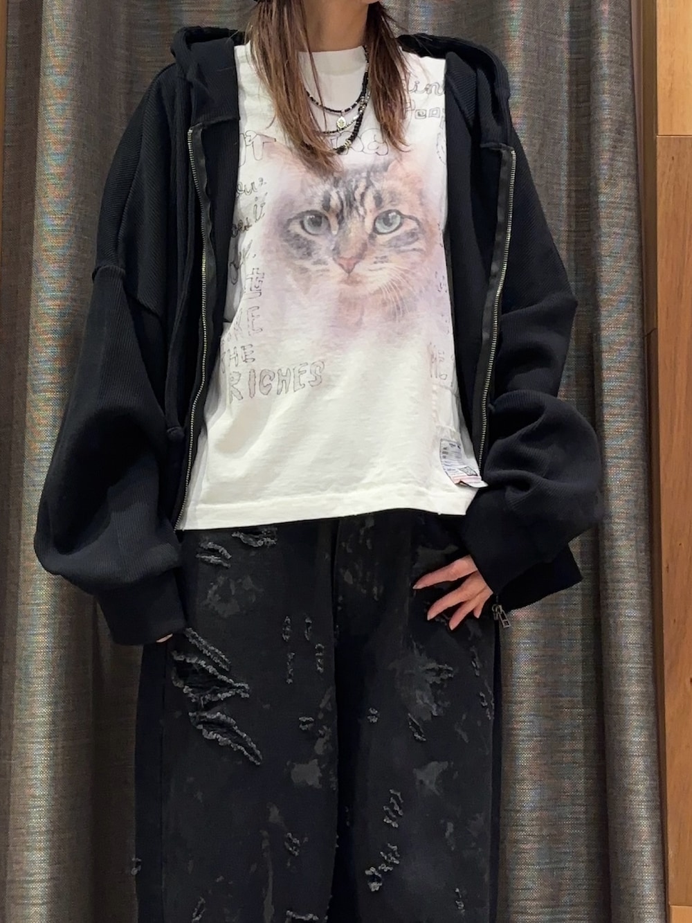 ブラック系のパーカー、ホワイト系のTシャツ/カットソー、ブラック系のデニムパンツを着用したレディースの冬コーディネートの5枚目の写真