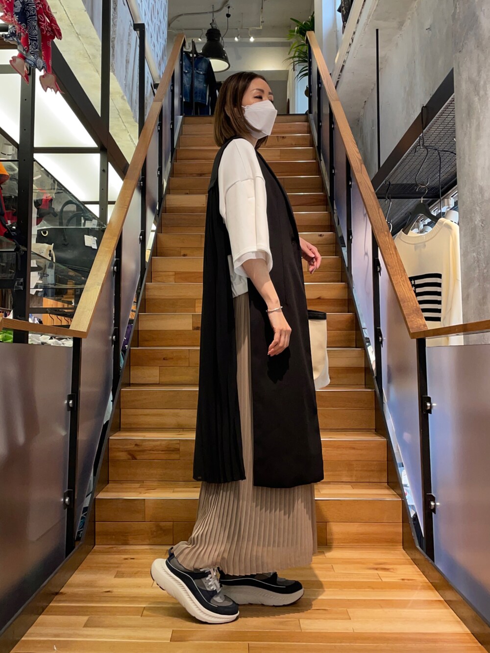 ホワイト系のTシャツ/カットソー、ブラック系のその他パンツ、ブラック系のベストを着用したレディースの春コーディネートの4枚目の写真