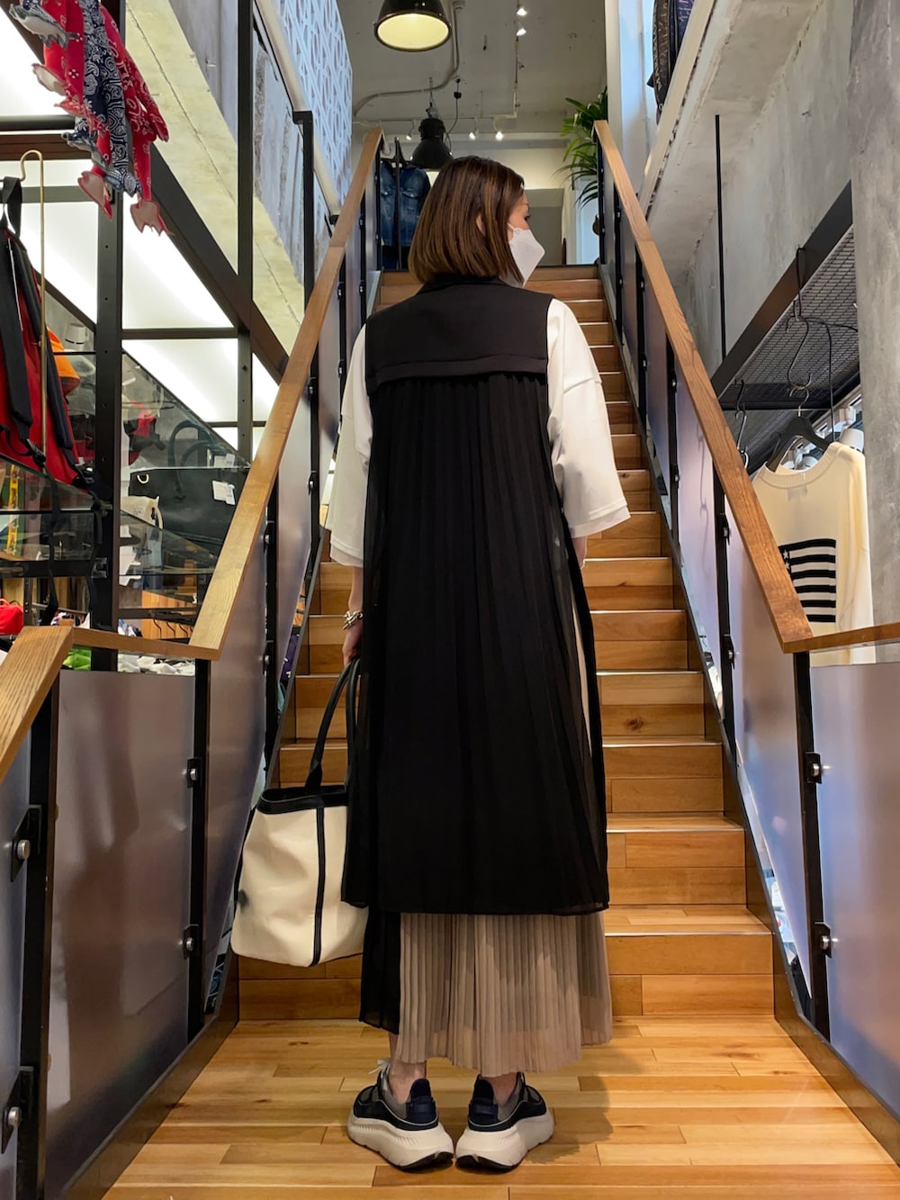 ホワイト系のTシャツ/カットソー、ブラック系のその他パンツ、ブラック系のベストを着用したレディースの春コーディネートの3枚目の写真