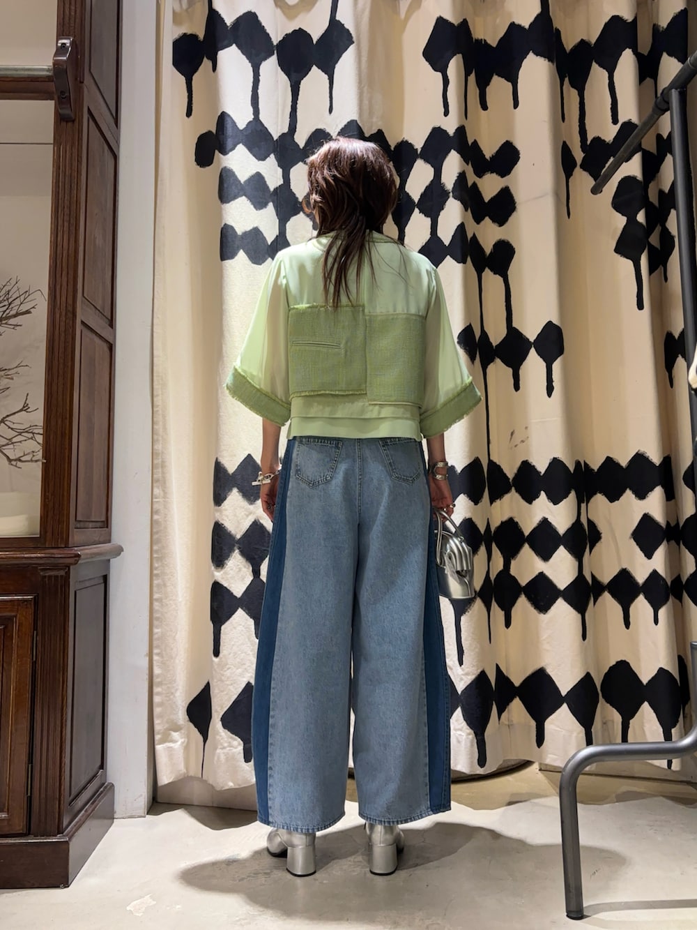 シルバー系のショルダーバッグ、グリーン系のシャツ/ブラウス、ブルー系のデニムパンツを着用したレディースの春コーディネートの3枚目の写真