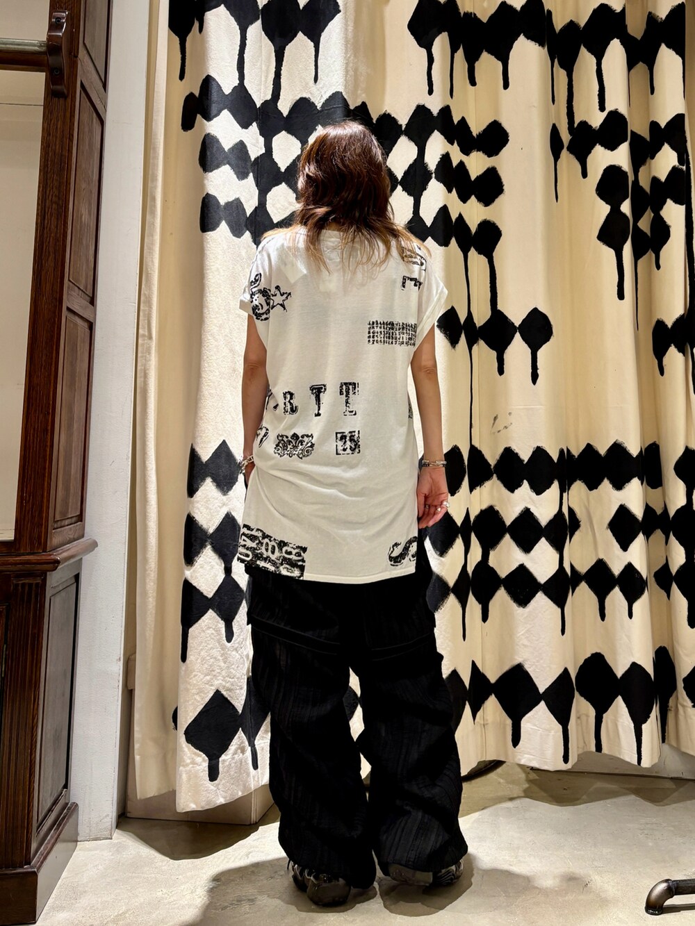 ブラック系のその他パンツ、ブラック系のスニーカー、ホワイト系のTシャツ/カットソーを着用したレディースの夏コーディネートの3枚目の写真