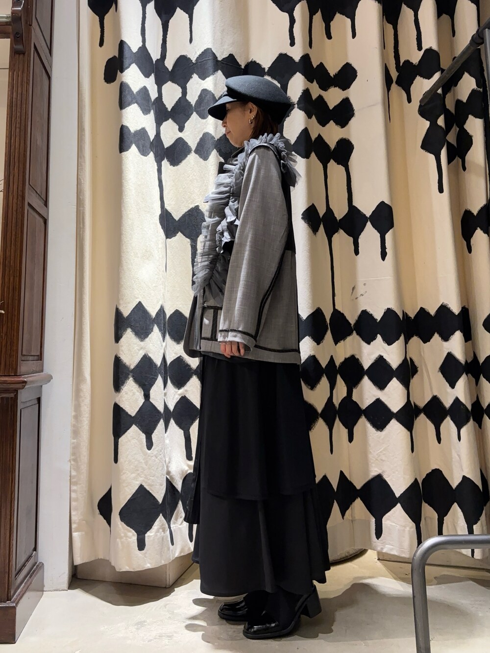 グレー系のテーラードジャケット、ブラック系のスカートを着用したレディースの冬コーディネートの2枚目の写真