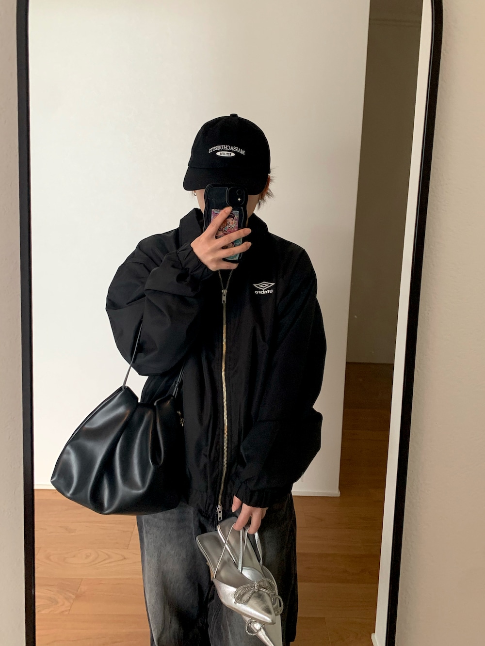 シルバー系のパンプス、ブラック系のデニムパンツ、ブラック系のブルゾンを着用したレディースの冬コーディネートの3枚目の写真