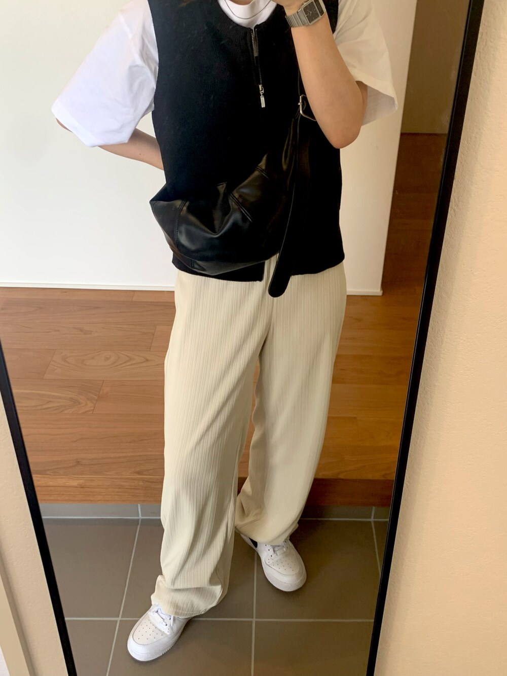 ブラック系のベスト、ホワイト系のTシャツ/カットソー、ホワイト系のパンツを着用したレディースの夏コーディネートの3枚目の写真