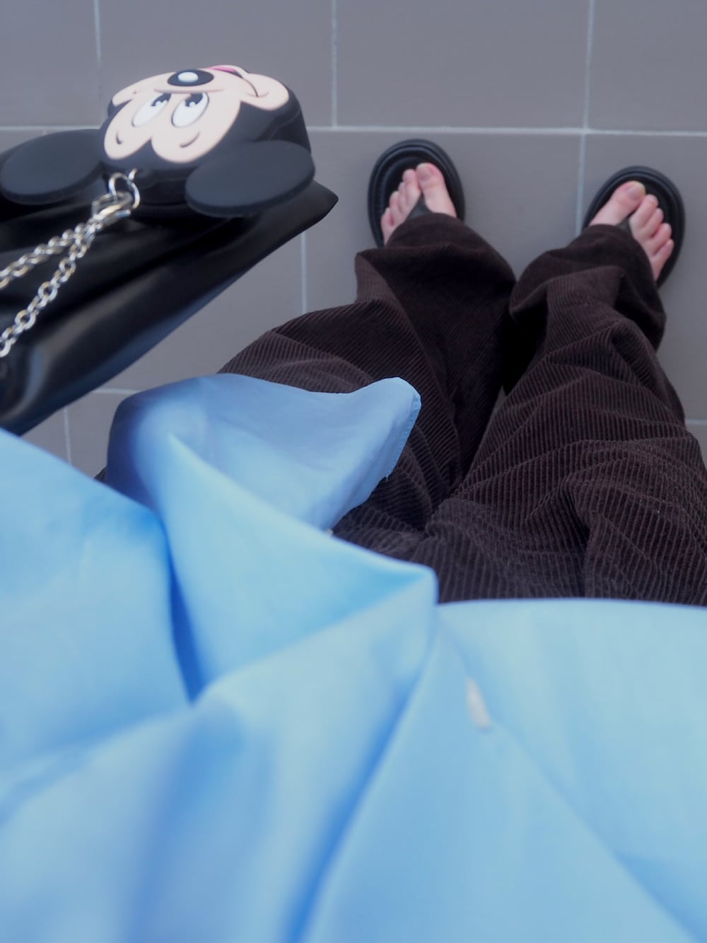 ブラック系のショルダーバッグ、ブルー系のシャツ/ブラウス、ブラウン系のパンツを着用したレディースの秋コーディネートの3枚目の写真