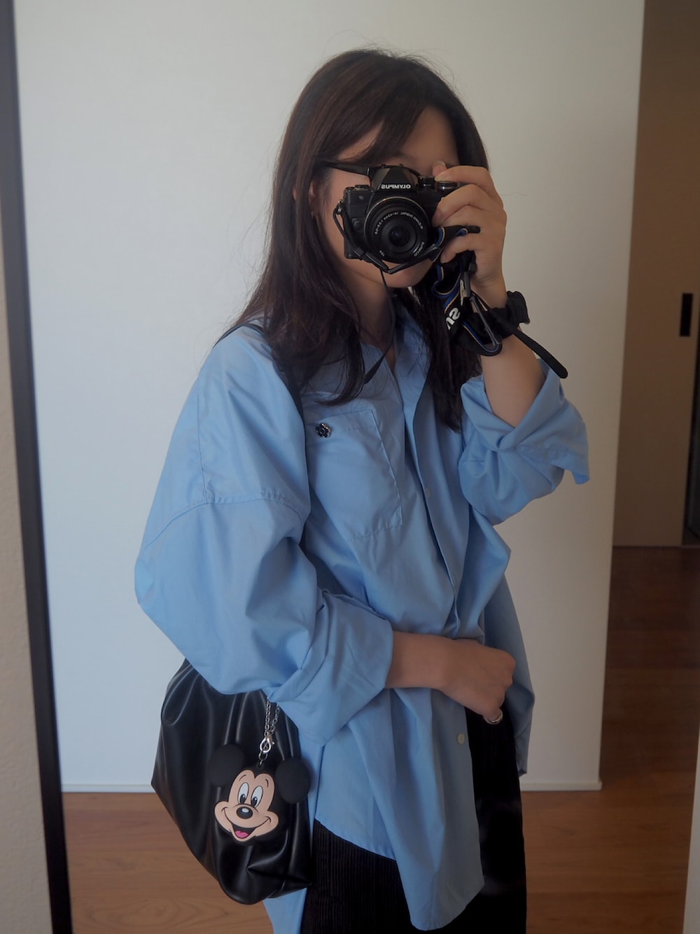 ブラック系のショルダーバッグ、ブルー系のシャツ/ブラウス、ブラウン系のパンツを着用したレディースの秋コーディネートの2枚目の写真