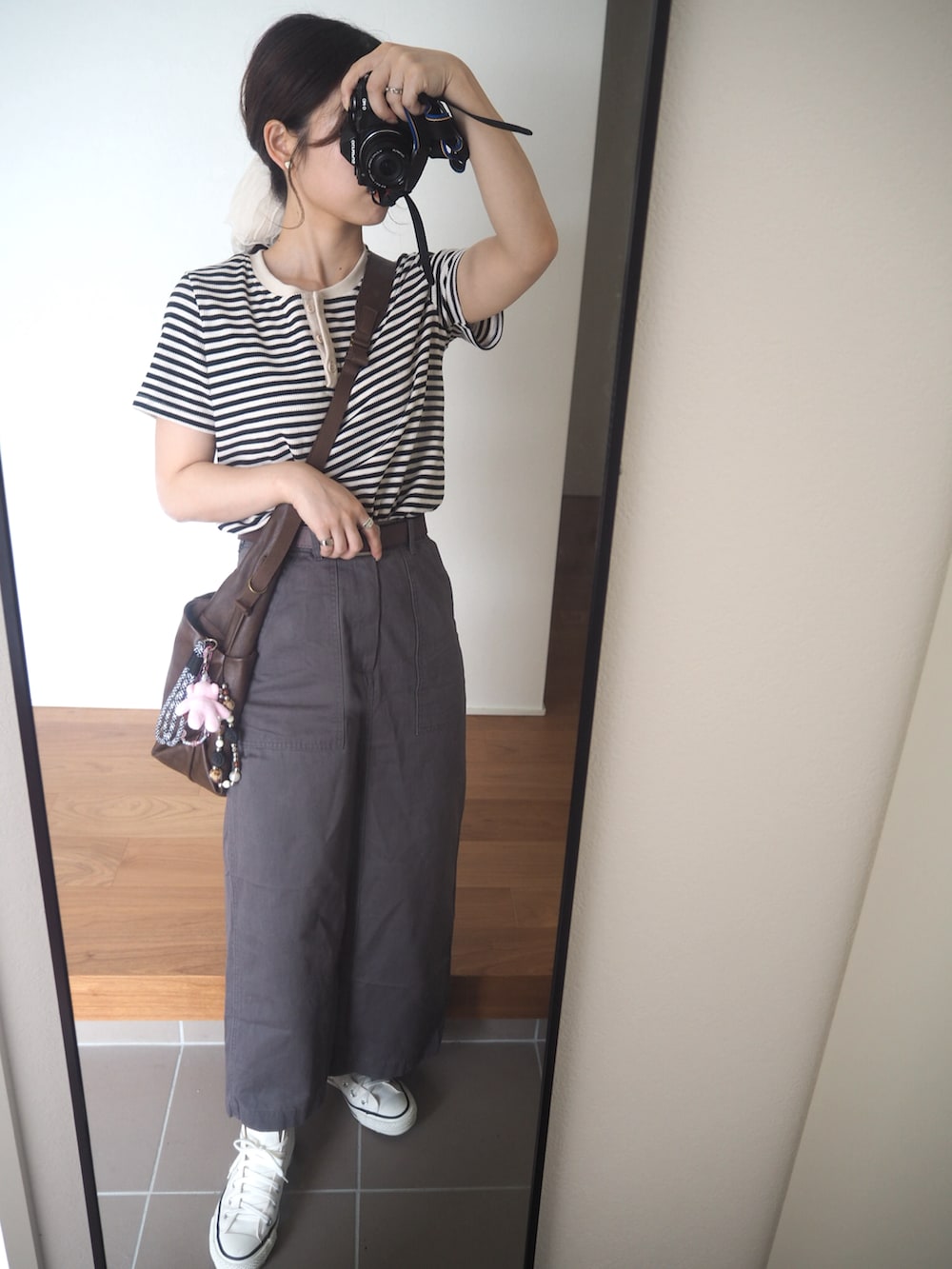 グレー系のスカート、ホワイト系のスニーカー、ホワイト系のTシャツ/カットソーを着用したレディースの秋コーディネートの2枚目の写真