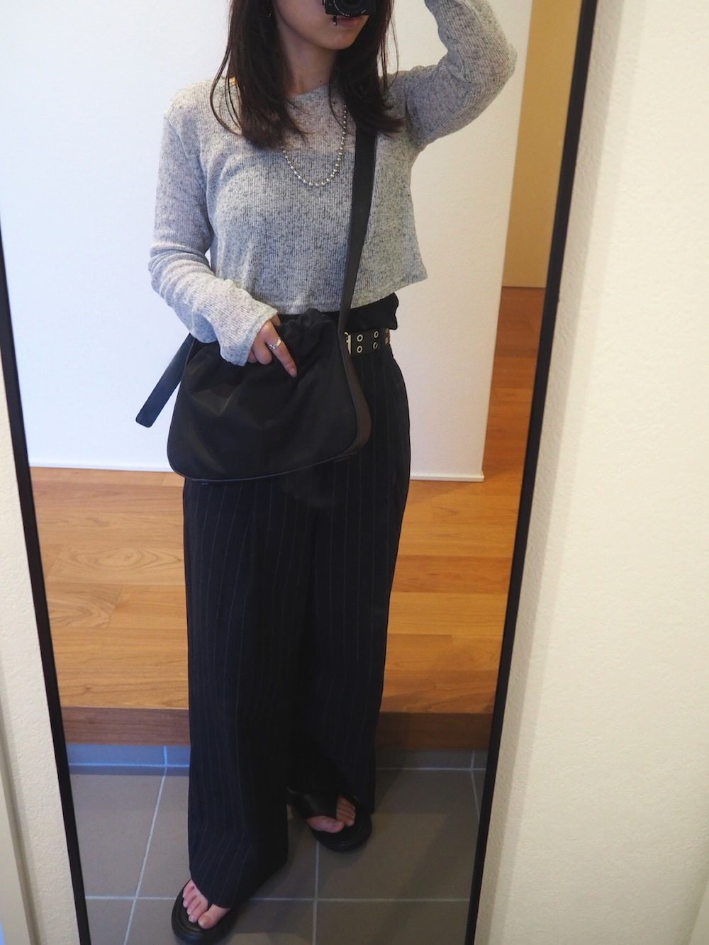 グレー系のTシャツ/カットソー、ブラック系のショルダーバッグ、ブルー系のパンツを着用したレディースの秋コーディネートの2枚目の写真