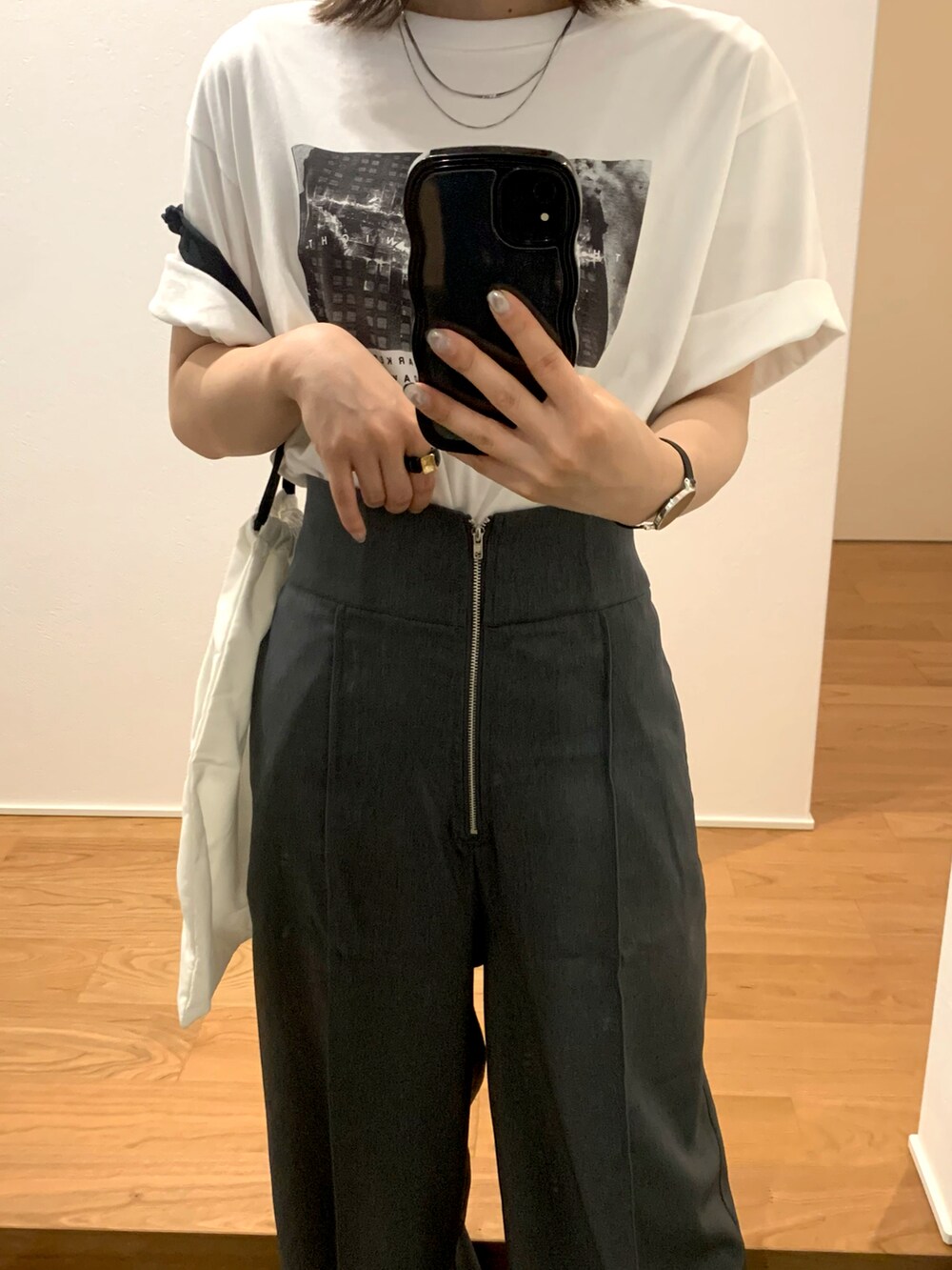 ホワイト系のTシャツ/カットソー、グレー系のスラックス、ブラック系のサンダルを着用したレディースの夏コーディネートの2枚目の写真