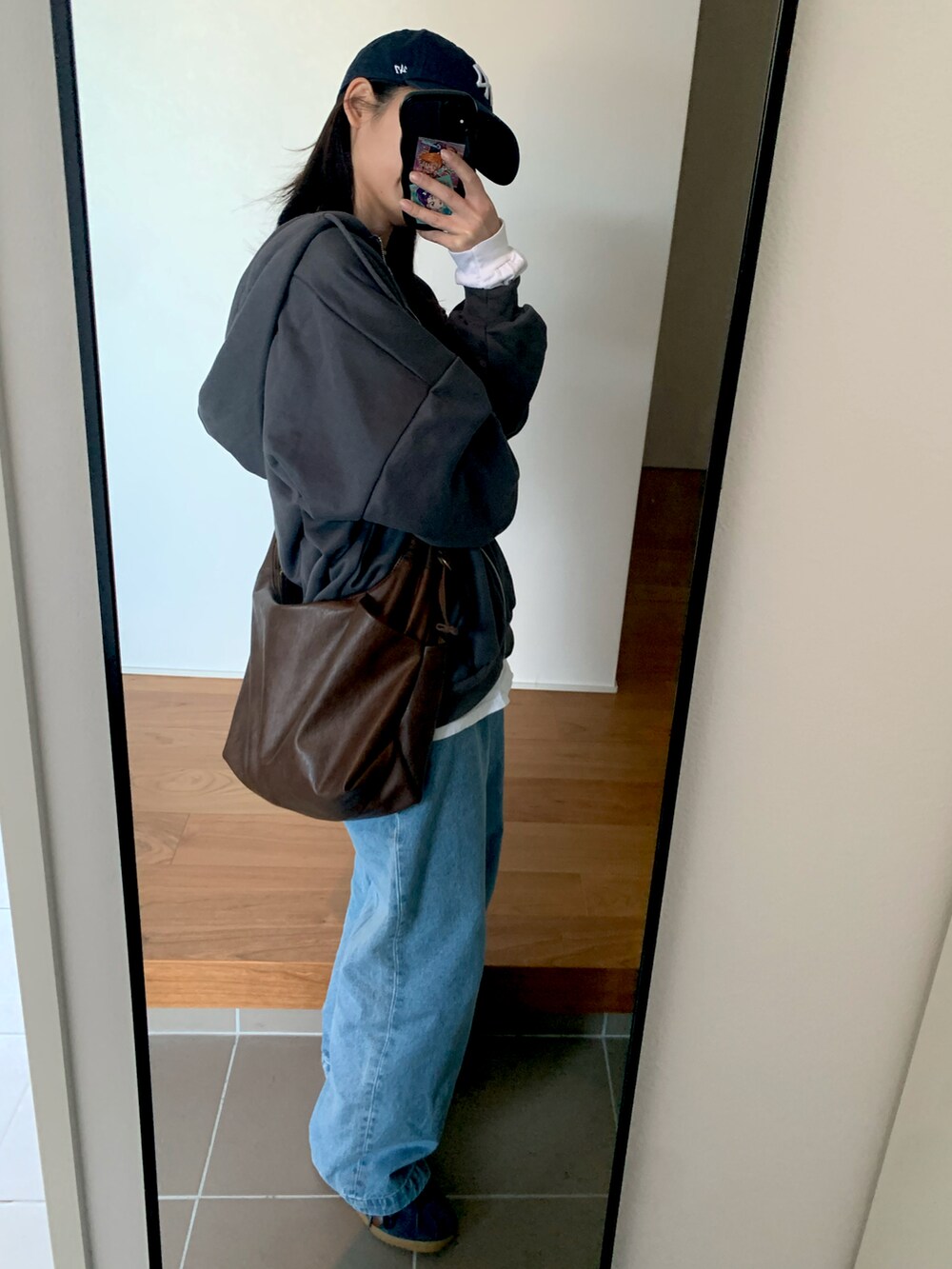 ホワイト系のTシャツ/カットソー、ブルー系のデニムパンツ、ブルー系のスニーカーを着用したレディースの冬コーディネートの3枚目の写真