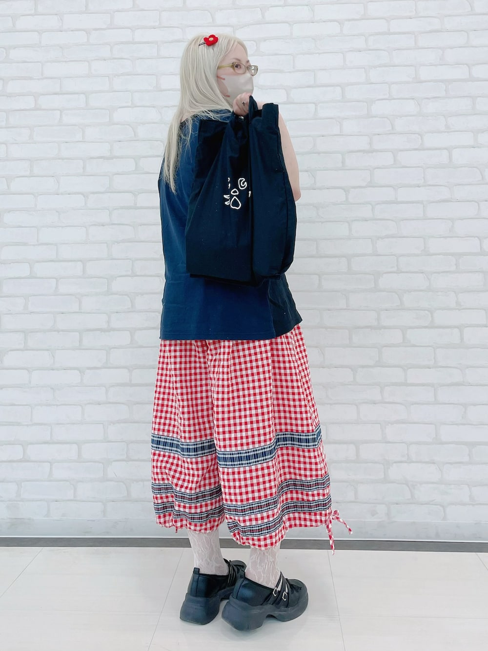 ブラック系のTシャツ/カットソー、レッド系のパンツ、ブラック系のトートバッグを着用したレディースの夏コーディネートの2枚目の写真
