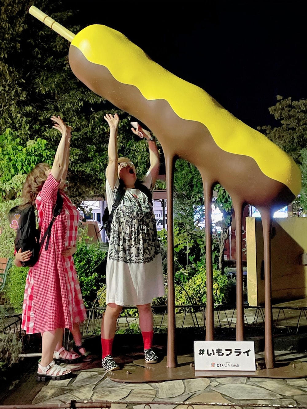 ホワイト系のワンピース、ブラック系のスニーカー、レッド系の帽子を着用したレディースの夏コーディネートの4枚目の写真
