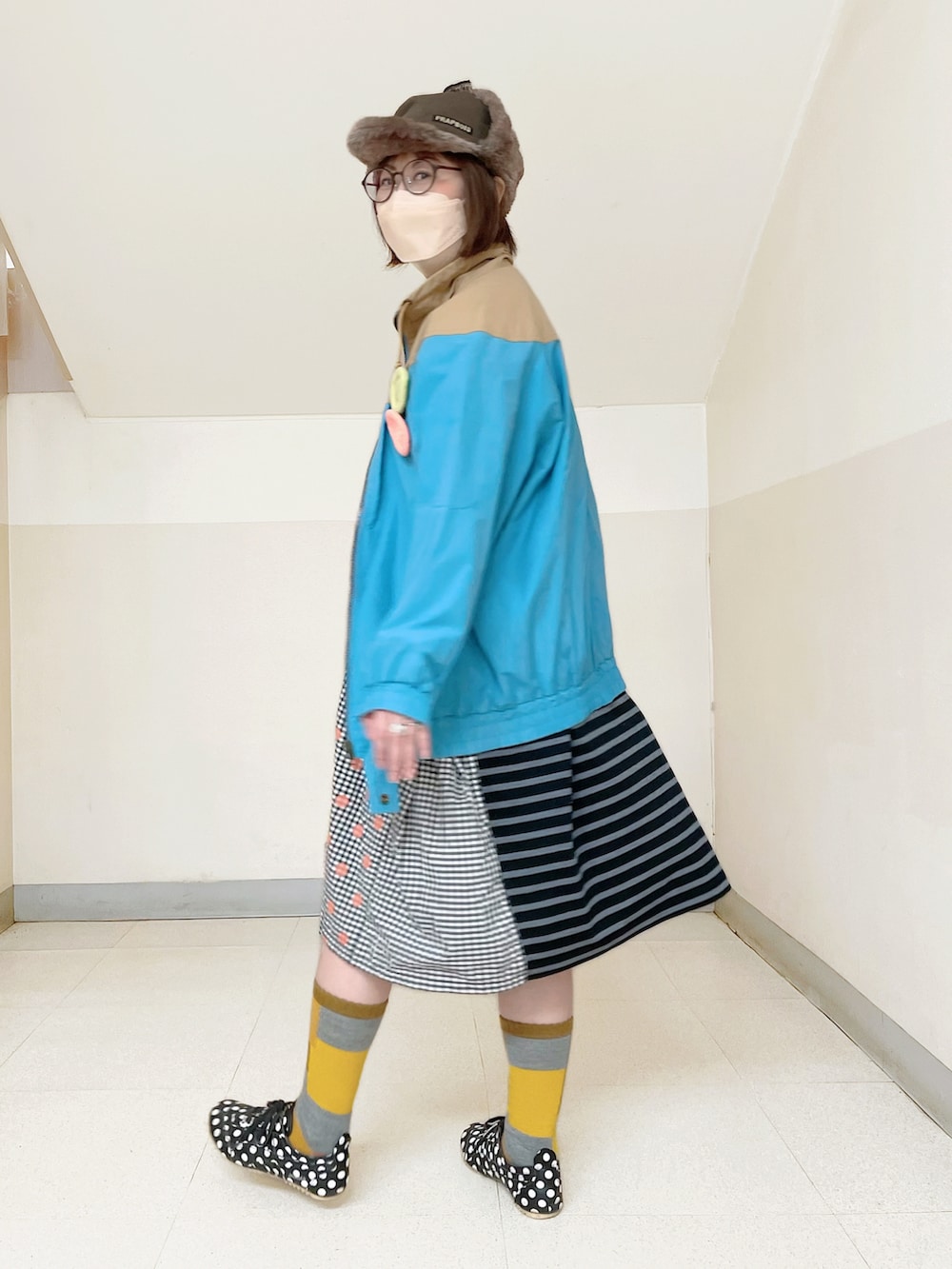 ブルー系のブルゾン、オレンジ系のワンピース、ブラック系のスニーカーを着用したレディースの秋コーディネートの2枚目の写真