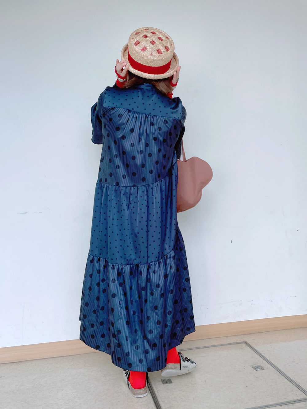 ブルー系のワンピース/ドレス、ブラウン系のトートバッグ、ブラック系のサンダルを着用したレディースの秋コーディネートの2枚目の写真