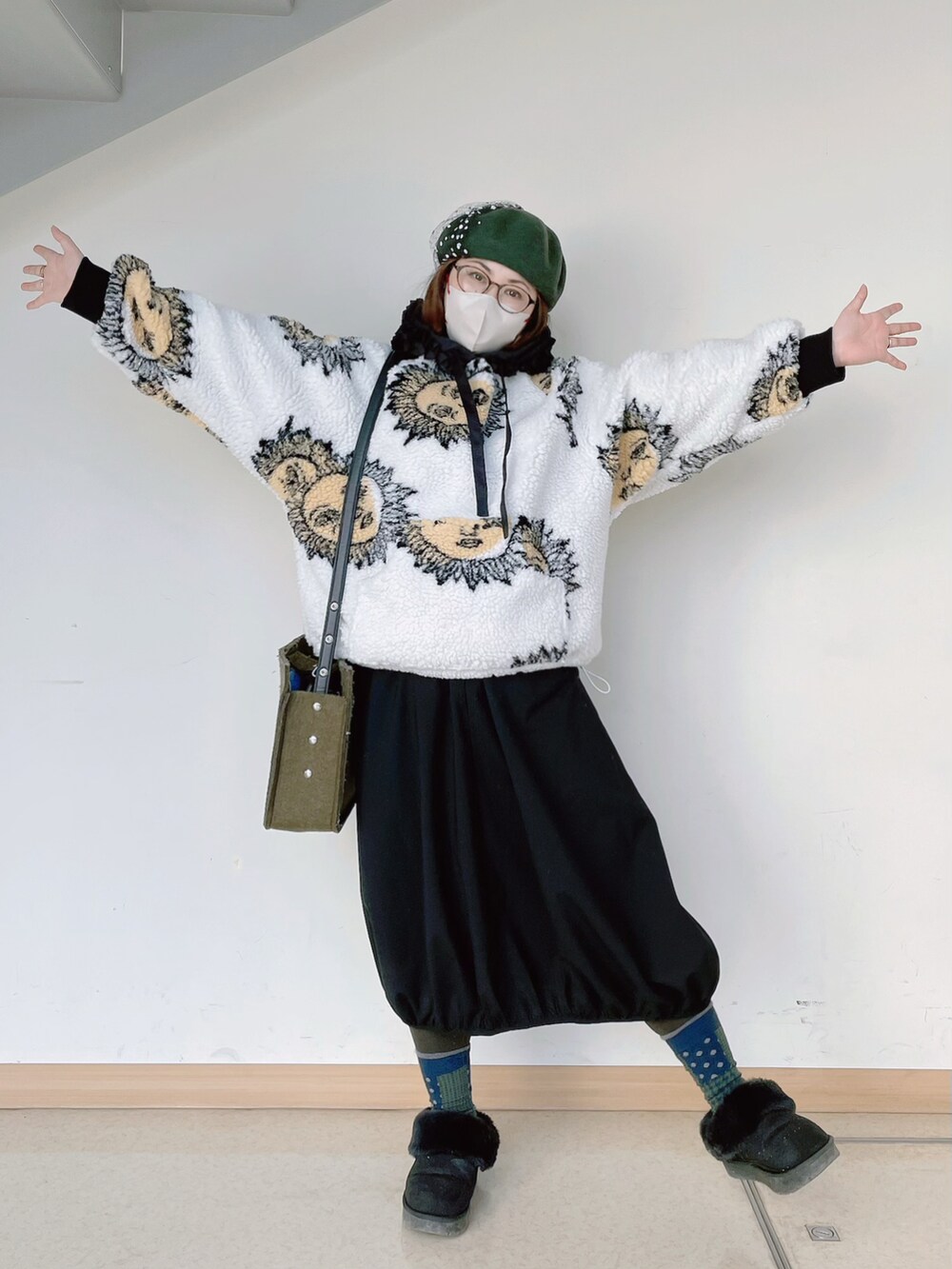 ホワイト系のトップス、グリーン系のショルダーバッグ、ブラック系のスカートを着用したレディースの冬コーディネートの4枚目の写真