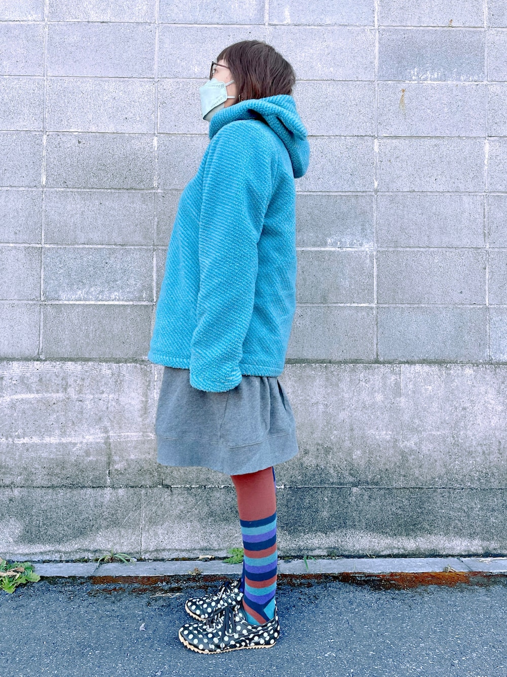 ブルー系のジャケット/アウター、グレー系のワンピース、ブラック系のスニーカーを着用したレディースの冬コーディネートの2枚目の写真