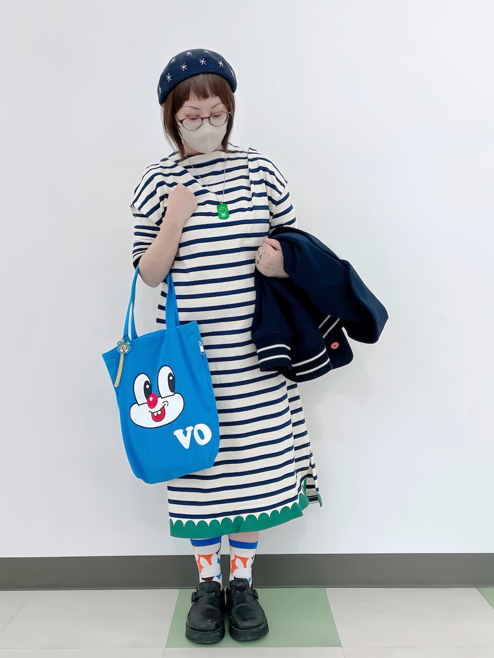 ブルー系のピーコート、ホワイト系のワンピース、ブルー系のトートバッグを着用したレディースの春コーディネートの2枚目の写真