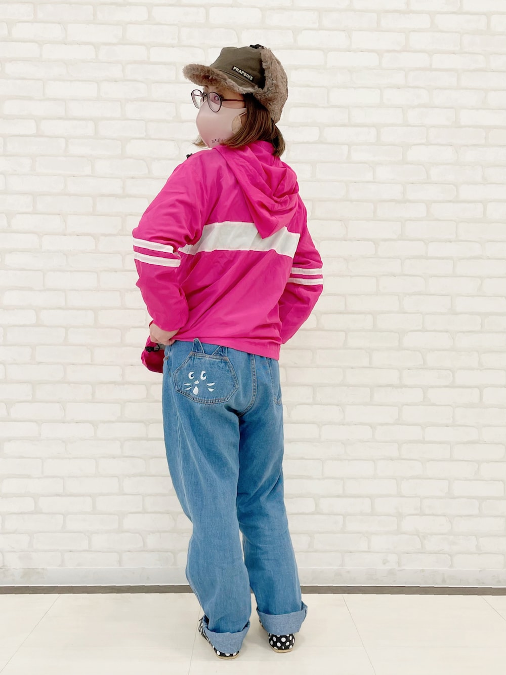ピンク系のブルゾン、ブルー系のデニムパンツ、ピンク系のスニーカーを着用したレディースの春コーディネートの2枚目の写真