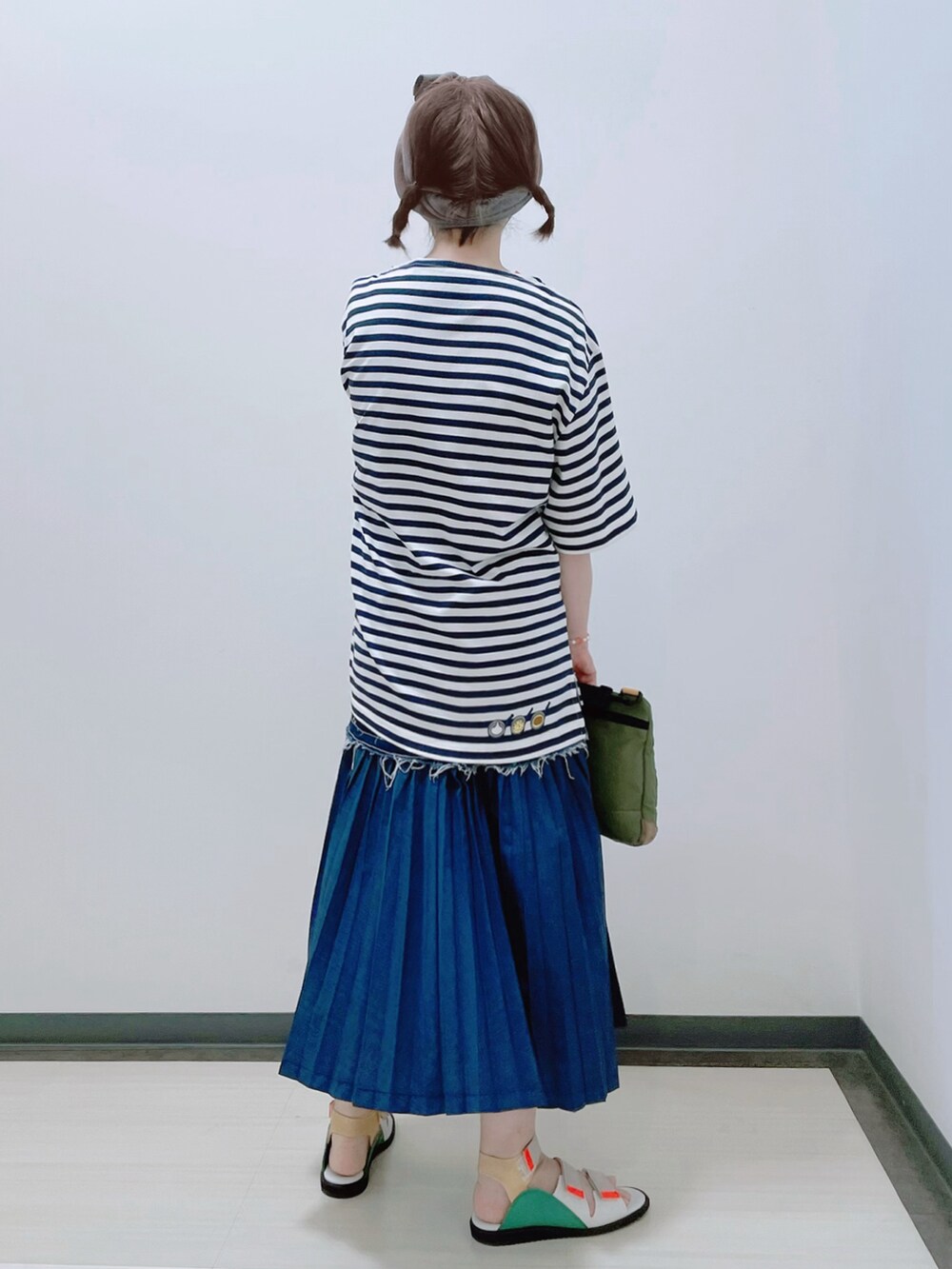 ホワイト系のトップス、グリーン系のショルダーバッグ、ブルー系のスカートを着用したレディースの夏コーディネートの3枚目の写真